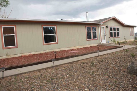 the front of a house with a yard and a sidewalk