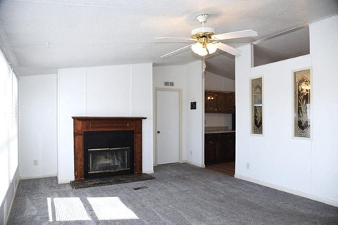 a living room with a fireplace and a ceiling fan