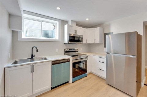 a kitchen with white cabinets and stainless steel appliances