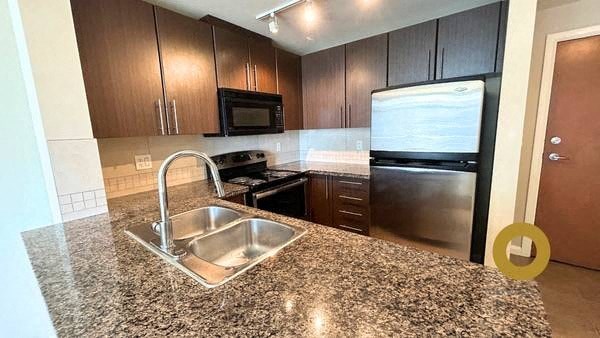 a kitchen with a stainless steel refrigerator and a sink