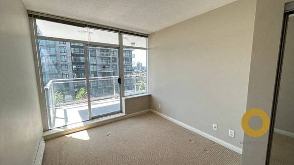 an empty living room with a large window and a balcony