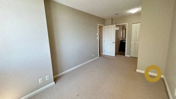 a empty room with a hallway and a door to a bedroom