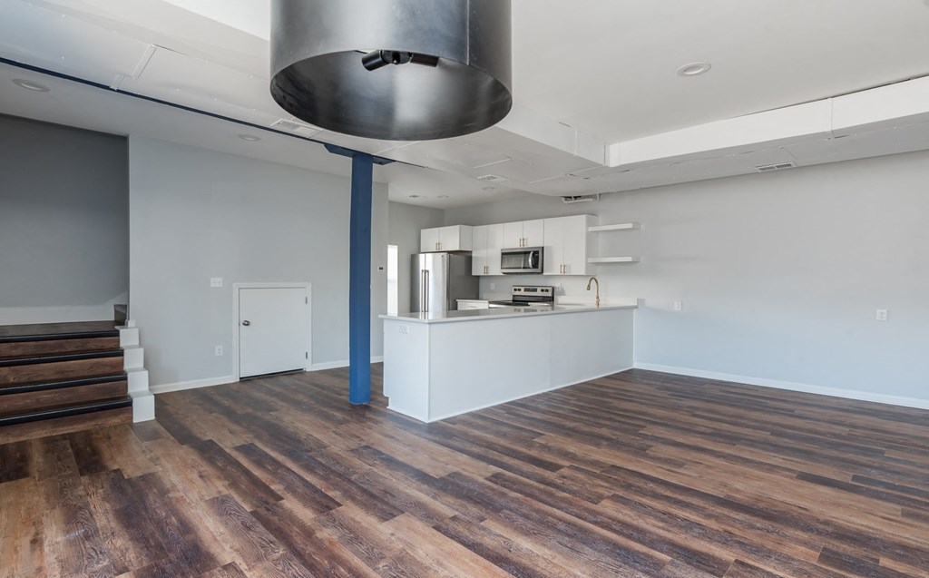the living room and kitchen of a house with wood flooring