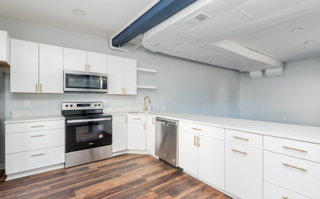 a kitchen with white cabinets and stainless steel appliances