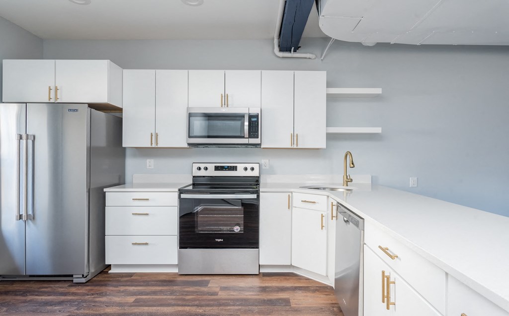 a kitchen with white cabinets and stainless steel appliances