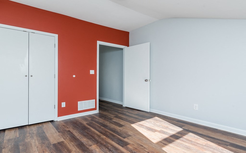 an empty room with red wall and white doors