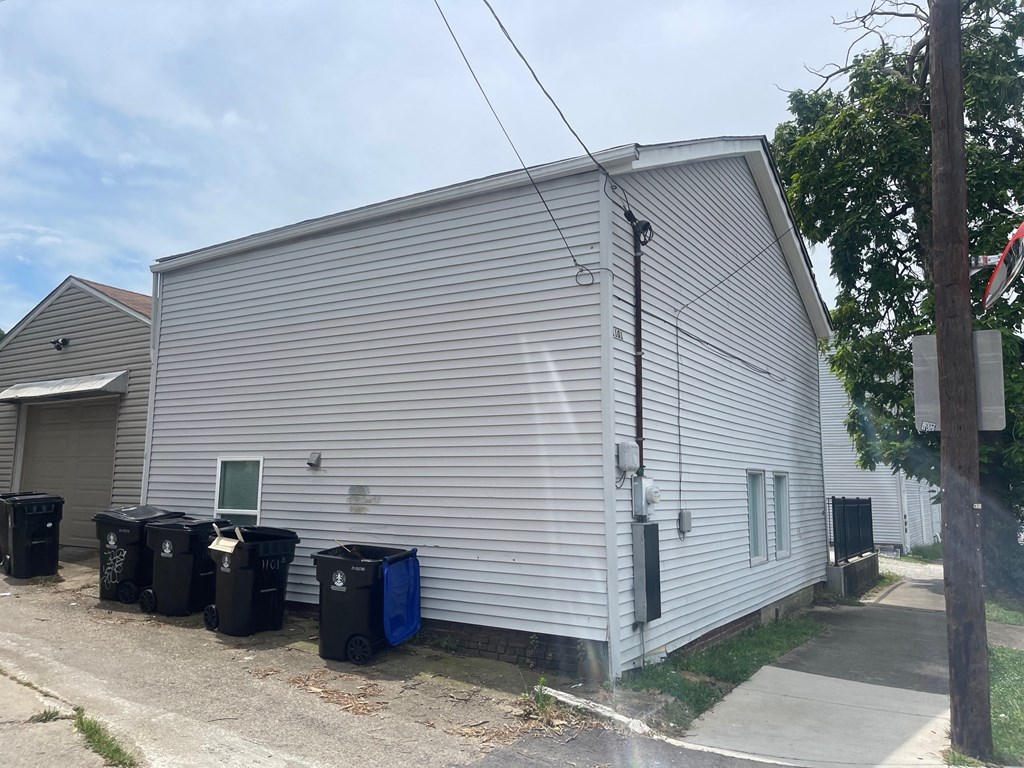 the side of a building with trash cans in front of it