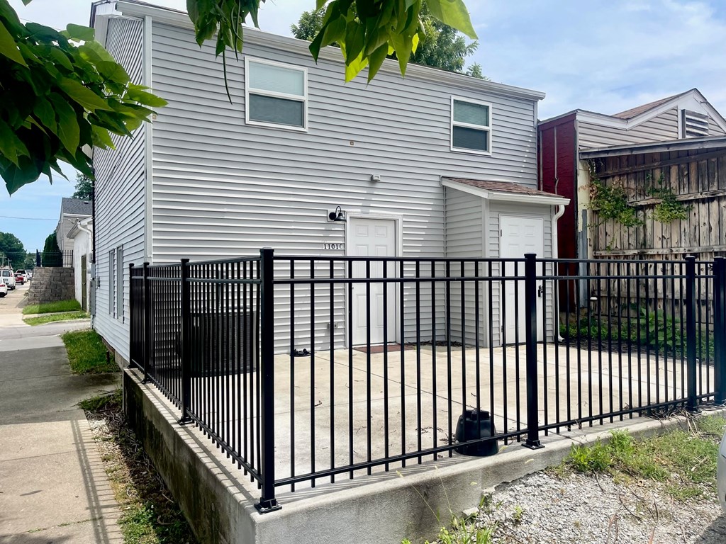 a white house with a black fence in front of it