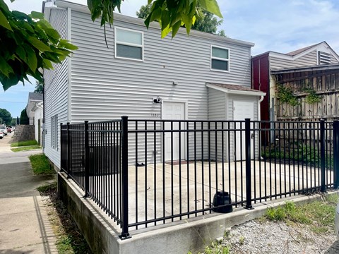 a white house with a black fence in front of it
