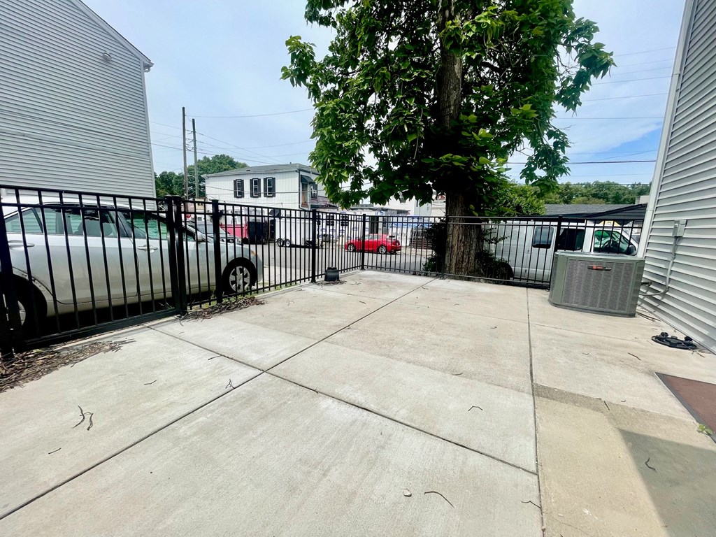 the back yard of a house with a fence and a tree