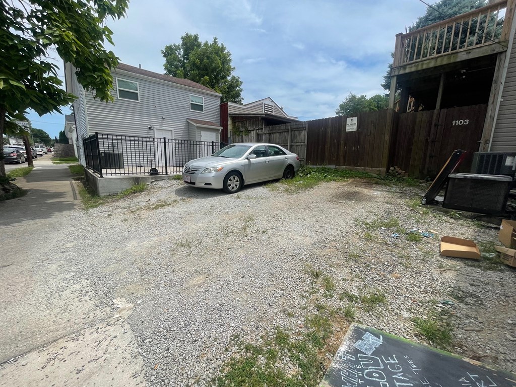a car parked in a gravel driveway in front of a house