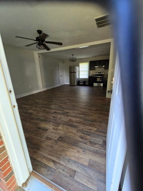 a living room with a wood floor and a ceiling fan