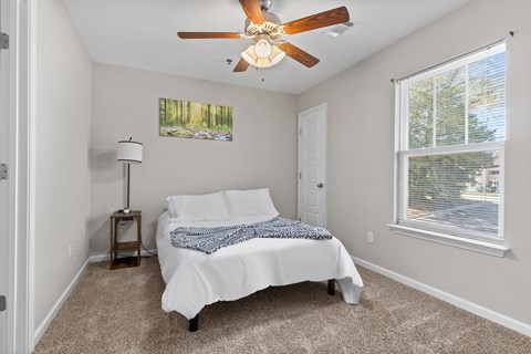 a bedroom with a bed and a ceiling fan