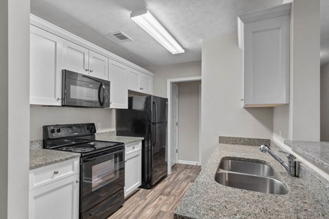 a kitchen with black appliances and granite counter tops