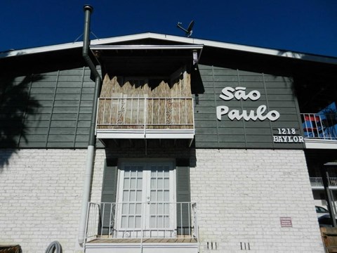 A building with a balcony and a sign that says Sao Paulo.