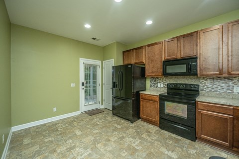 a kitchen with black appliances and wooden cabinets