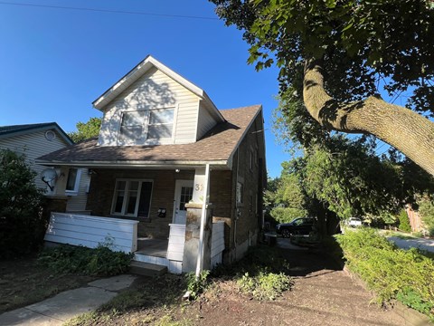 a small house with a tree in front of it