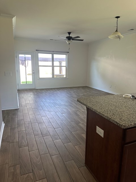 an empty kitchen and living room with wood flooring