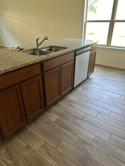 a kitchen with a counter and a sink and a window