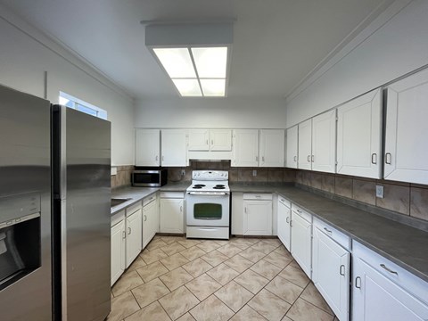 A kitchen with white cabinets and a tiled floor.