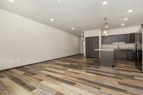 A kitchen with a wooden floor and a white wall.