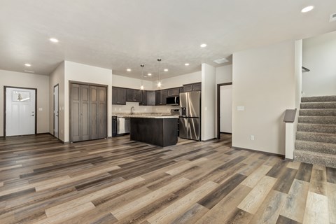 A spacious living room with a staircase on the right side.