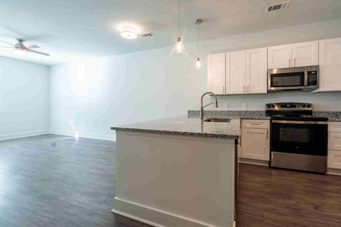 A kitchen with a stove, microwave, and oven.