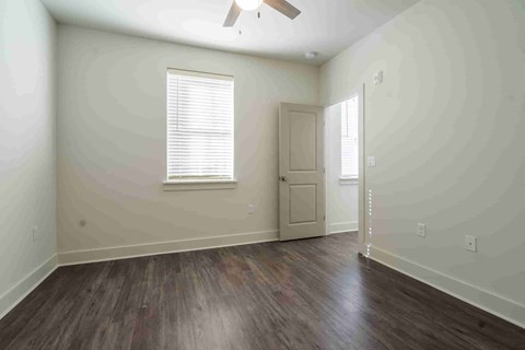 A room with a wooden floor and a ceiling fan.