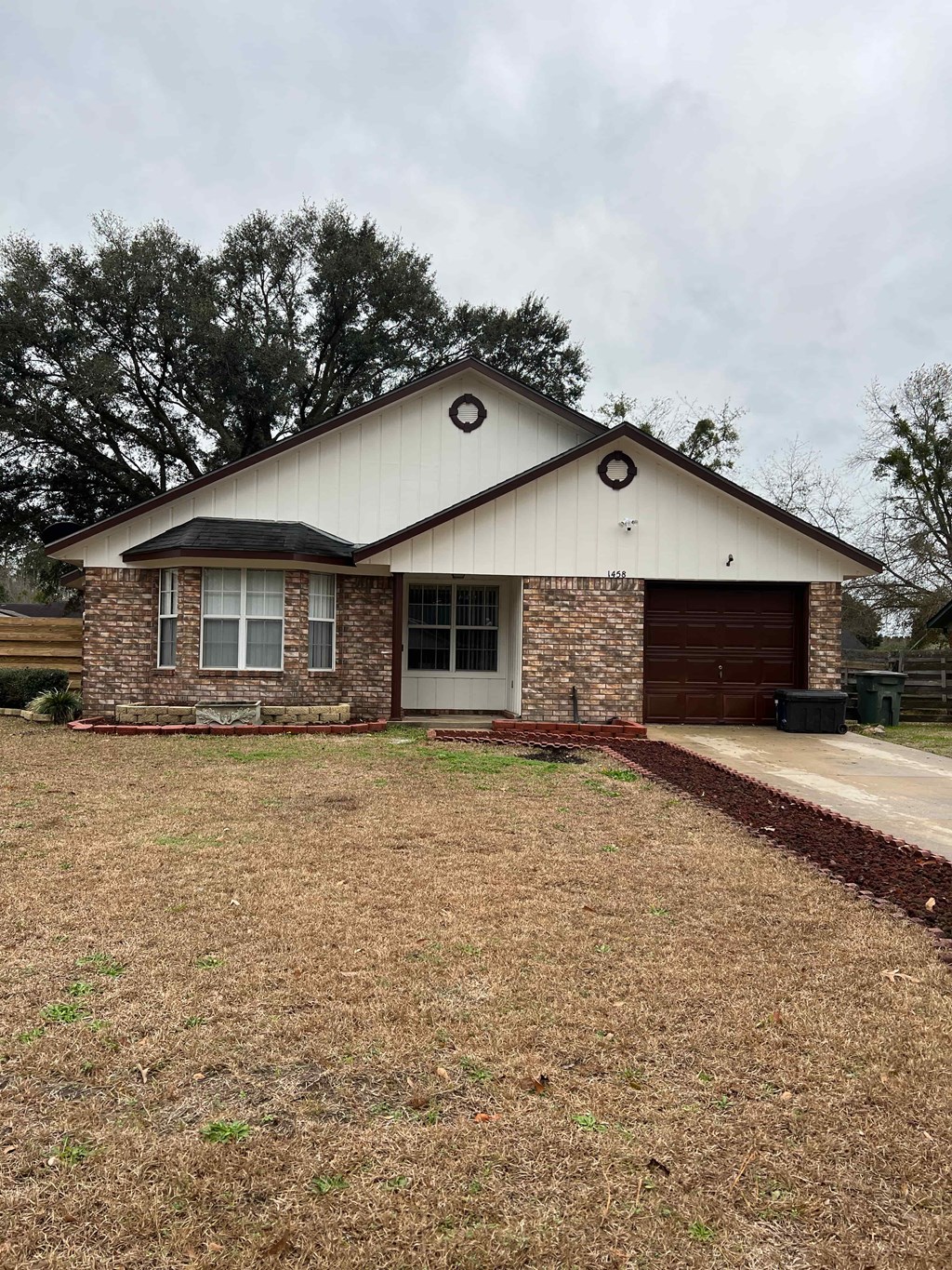 the front of a house with a lawn and a driveway