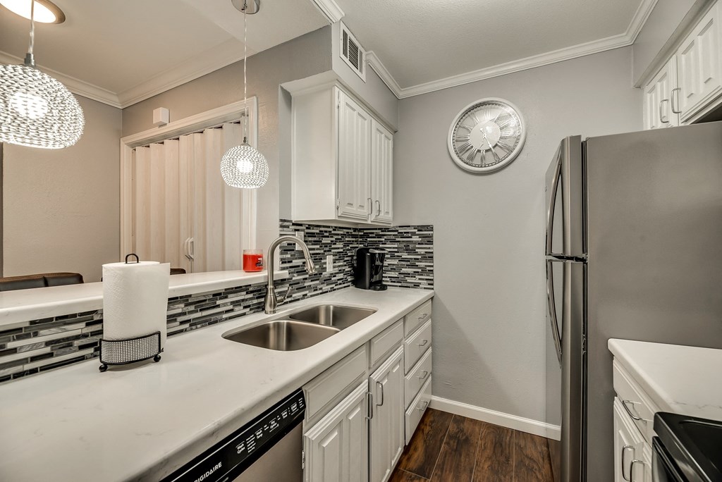 a kitchen with white cabinets and a sink and a refrigerator