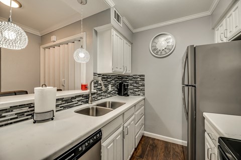 a kitchen with white cabinets and a sink and a refrigerator