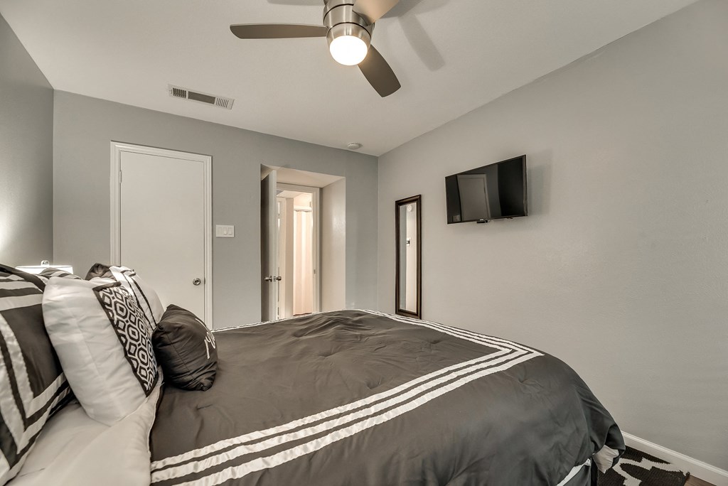 the master bedroom has a large bed and a ceiling fan