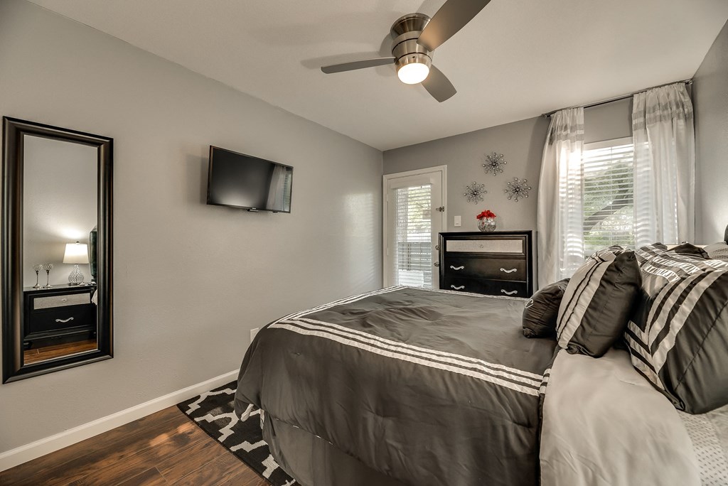 the master bedroom has a large bed and a ceiling fan