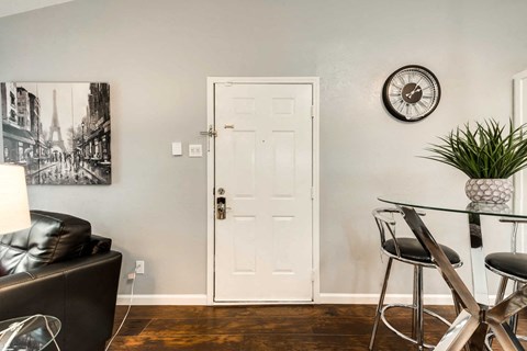 a living room with a white door and a table and chairs