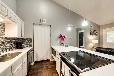 a kitchen with a stove top oven and a sink