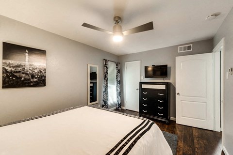 a bedroom with a bed and a ceiling fan