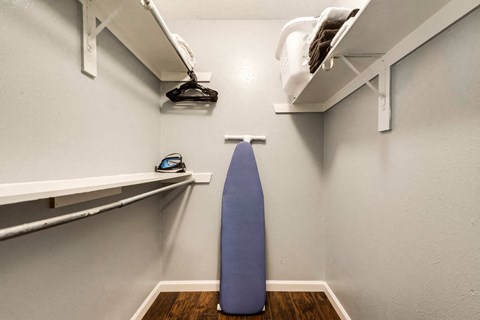 a closet with a blue surfboard in it and shelves
