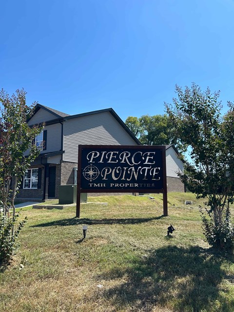 A sign for Pierce Pointe TMH Properties in front of a house.