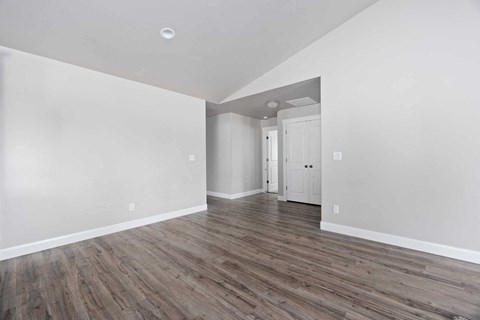an empty living room with white walls and wood floors
