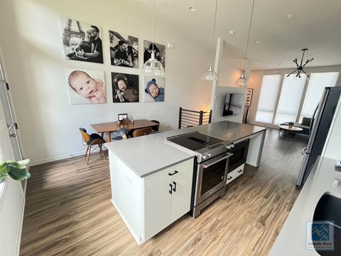 a kitchen and living room with a stove and a counter top
