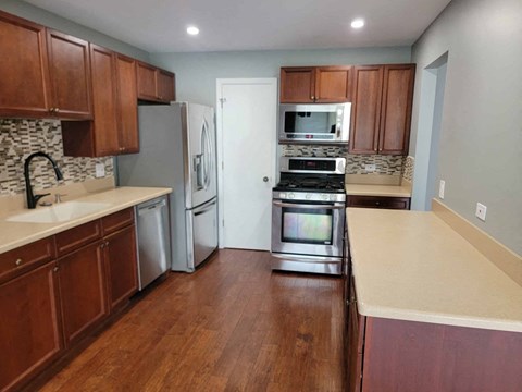 a kitchen with wooden cabinets and stainless steel appliances