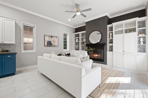 A living room with a white couch and a fireplace.