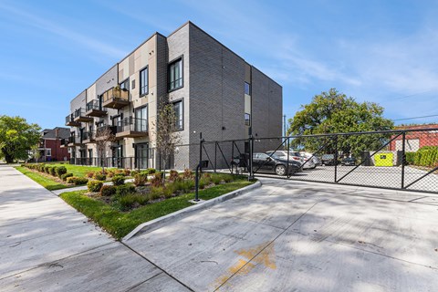 A modern apartment building with a parking lot in front.