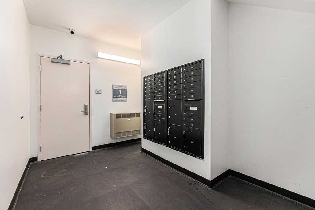 A black control panel with white numbers and letters is on a white wall.