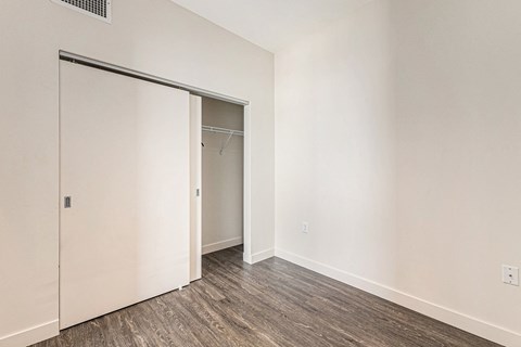 A room with a white door and a brown floor.