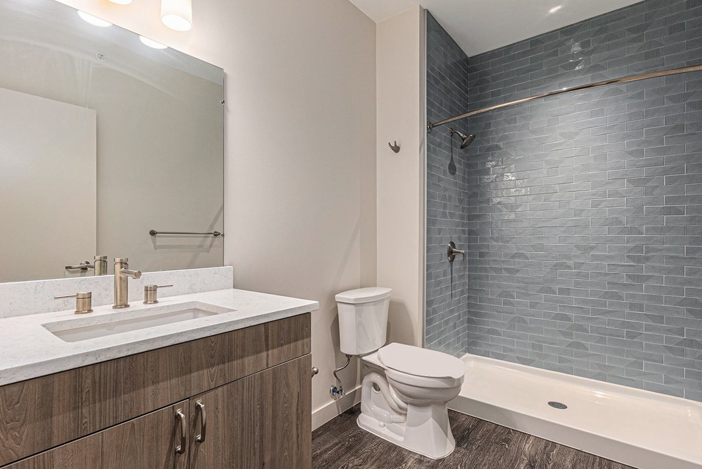A white toilet sits next to a bathtub in a bathroom.