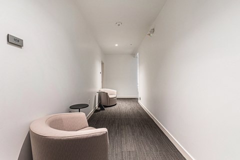 A hallway with a chair and a table.