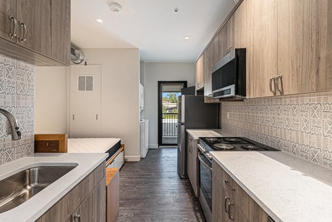 A kitchen with a black stove top oven and a black microwave.