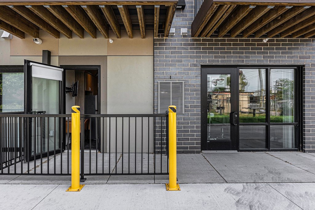 A black and yellow bollard stands in front of a building.