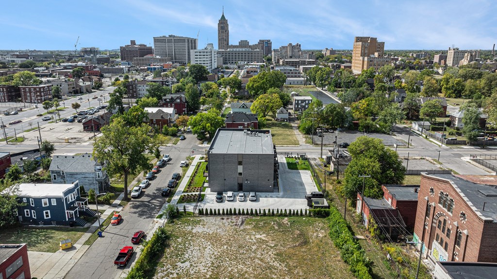 A cityscape with a large building in the center and a tall tower in the distance.